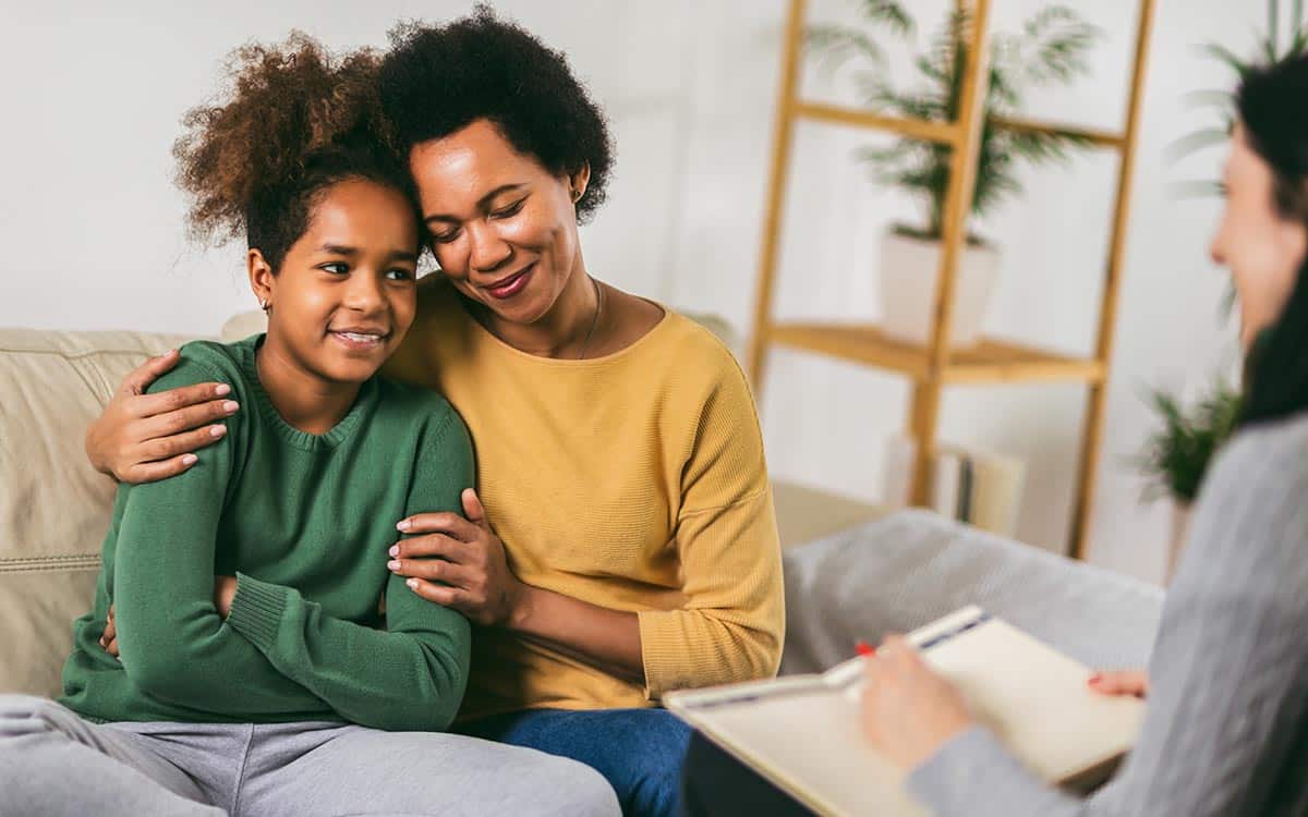 Mother and her teenager daughter talking with therapist.