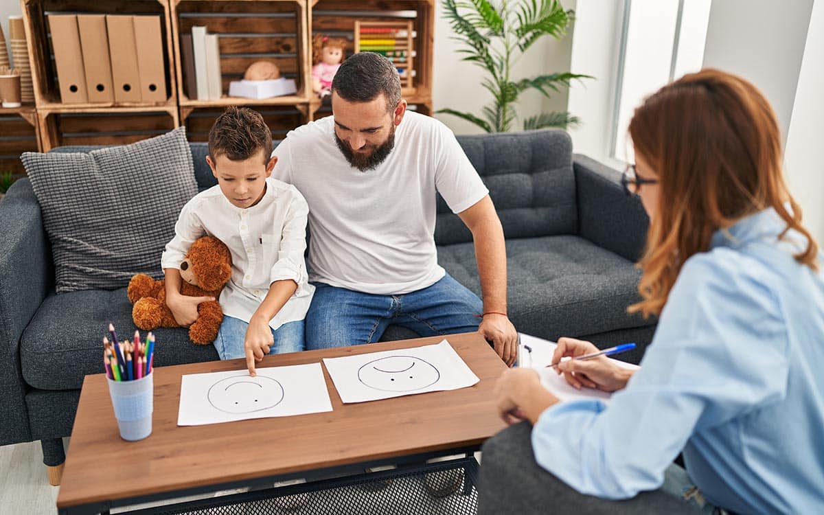 Family having psychology session choosing emotion emoji draw at psychology center