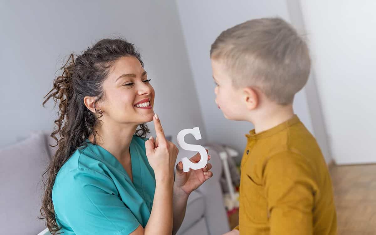 Speech therapist and little patient training articulation